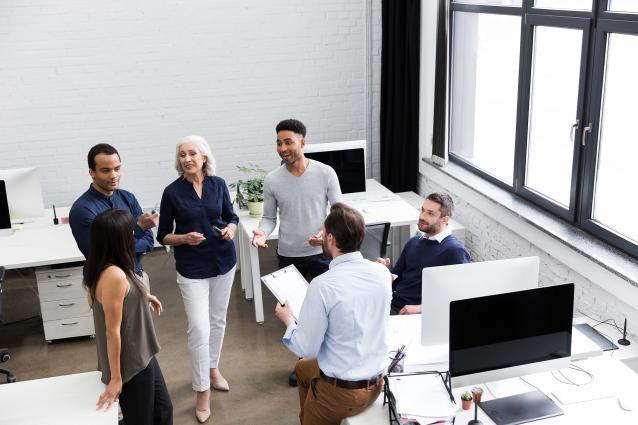 Groupe de personnes discutant dans un bureau.