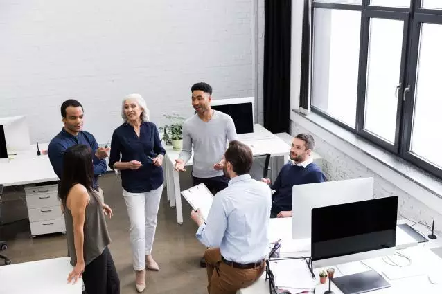 Groupe de personnes discutant dans un bureau.