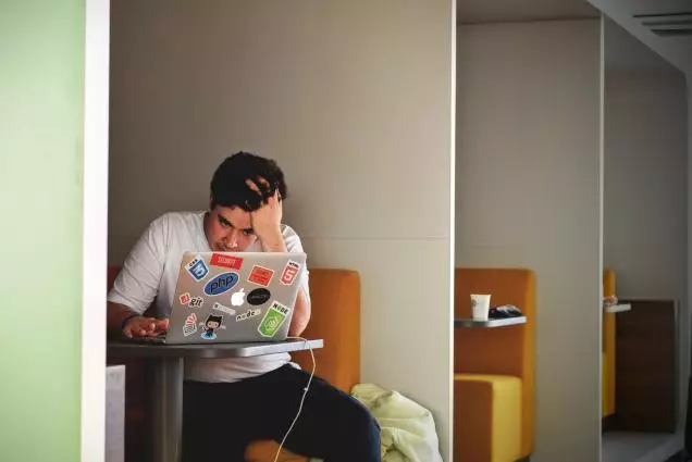 jeune homme travaillant sur un ordinateur dans un open space